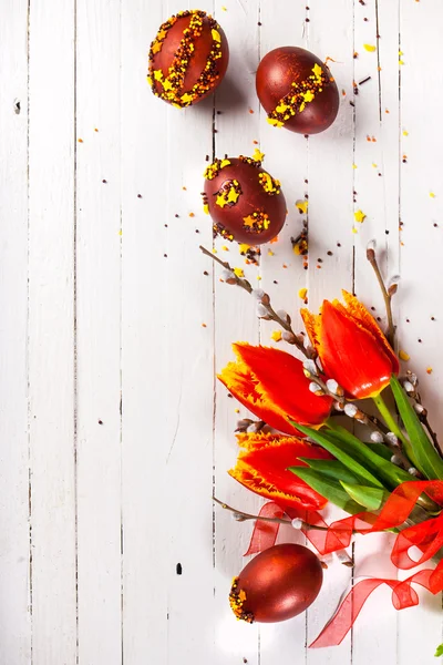 Een boeket van tulpen en paaseieren op witte achtergrond — Stockfoto