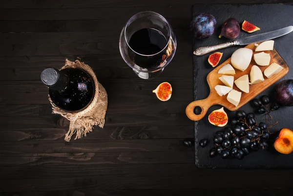 Fondo gastronomico con vino rosso, fichi, uva e formaggio — Foto Stock