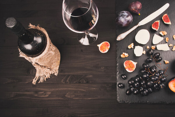 Food background with red wine, figs, grapes and cheese