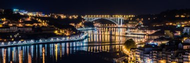 Porto, Portekiz. Old Town görünümünü. Gece cityscape. Geleneksel Rabelo ile Douro nehir gece fener ışığında tekneler..