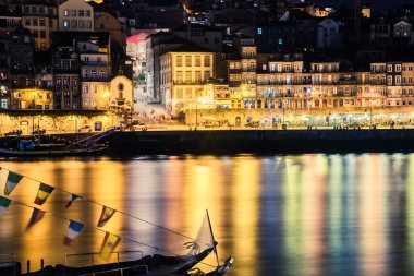 Porto, Portekiz. Old Town görünümünü. Gece cityscape. Geleneksel Rabelo ile Douro nehir gece fener ışığında tekneler..