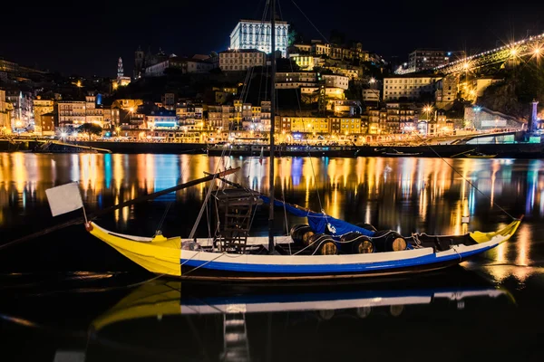 Porto, Portugal. Uitzicht op de oude stad. Nacht stadsgezicht. Dourorivier met de traditionele Rabelo boten in de nacht het licht van de lantaarns. — Stockfoto