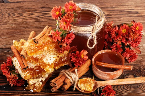 Соты и мед на деревянной поверхности — стоковое фото
