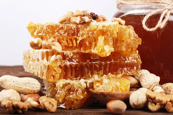 Соты и мед на деревянной поверхности — стоковое фото