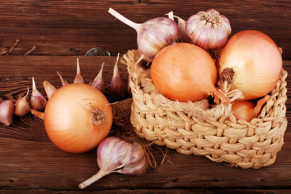 Komposition mit Zwiebel und Knoblauch auf einer Holzoberfläche — Stockfoto