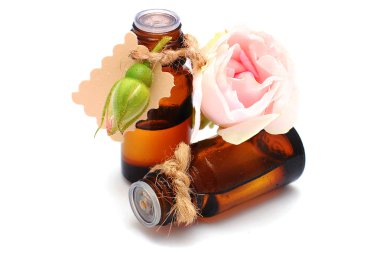 Beyaz arka plan üzerinde izole Gül yağı ile şişe