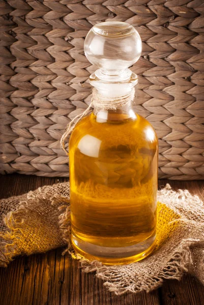 Láhev s olej na dřevěné desce — Stock fotografie