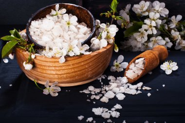 Spa kavramı koyu arka plan üzerinde. Deniz tuz, çiçekli dallar kiraz, aromatik yağlar
