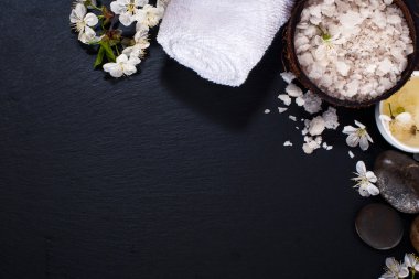 Spa kavramı koyu arka plan üzerinde. Deniz tuz, çiçekli dallar kiraz, aromatik yağlar