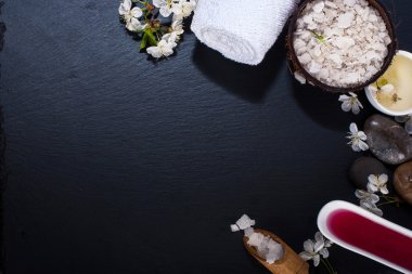 Spa kavramı koyu arka plan üzerinde. Deniz tuz, çiçekli dallar kiraz, aromatik yağlar