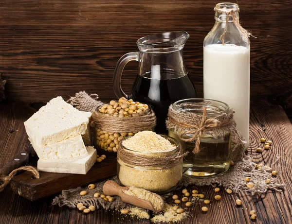 Produtos de soja (farinha de soja, tofu, leite de soja, molho de soja) em um fundo de madeira. estilo rústico — Fotografia de Stock