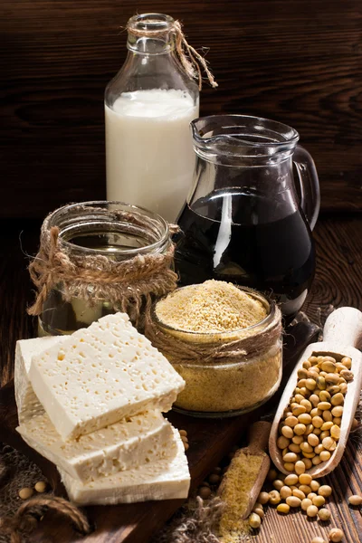 Соевые продукты (соевая мука, тофу, соевое молоко, соевый соус) на деревянном фоне. деревенский стиль — стоковое фото