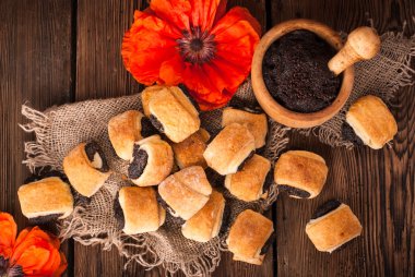 Ahşap bir masa üzerinde rulo haşhaş tohumu ile. rustik tarzı