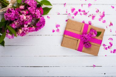 Bir hediye ve ahşap bir yüzey üzerinde çiçekler ile klasik arka plan