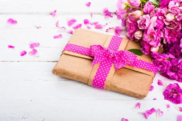 Fondo vintage con un regalo y flores en una superficie de madera —  Fotos de Stock