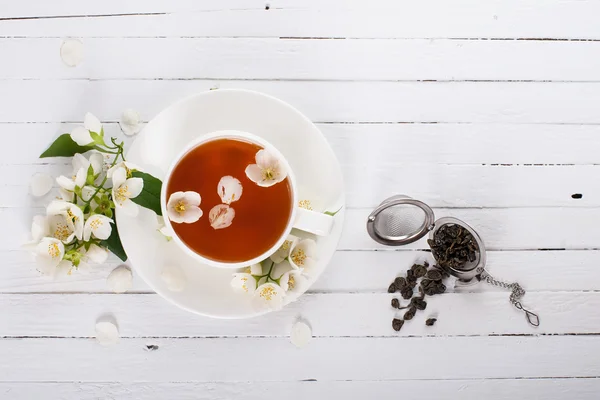 A cup of green tea with jasmine on a white surface — Stok fotoğraf