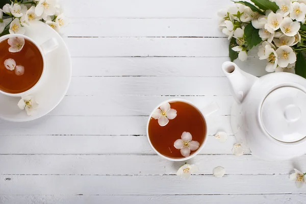 Zwei Tassen und eine Teekanne grünen Tees mit Jasmin auf einer weißen Oberfläche — Stockfoto