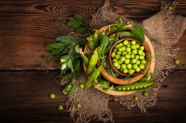 Ahşap arka plan üzerinde taze organik yeşil bezelye. Rustik tarzı.