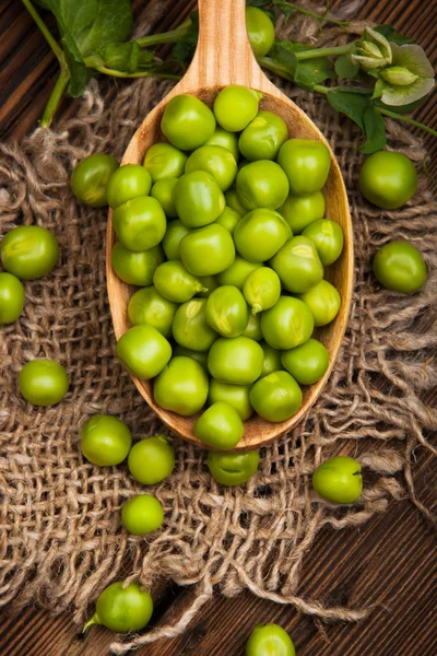 Ervilhas verdes orgânicas frescas em um fundo de madeira. Estilo rústico . — Fotografia de Stock