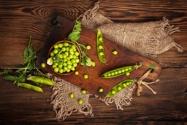 Frische grüne Bio-Erbsen auf einem hölzernen Hintergrund. rustikaler Stil. — Stockfoto