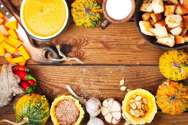 Pumpkin soup on wooden background. Ingredients for cooking. — Stock Photo, Image