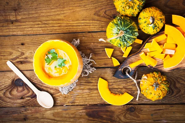 Pumpkin soup on wooden background. Ingredients for cooking. — Stock Photo, Image