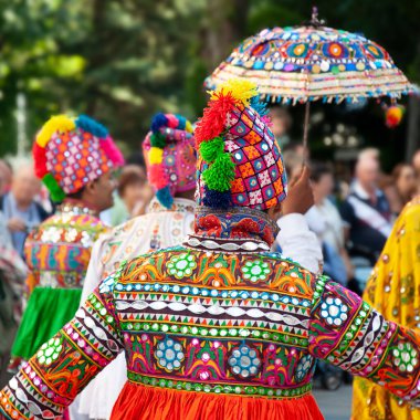 Birkaç dansçı dans ediyor ve Hindistan 'dan geleneksel halk kostümünü giyiyorlar.