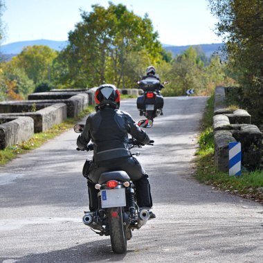 Bir yoldaki iki motorcunun arka görüntüsü