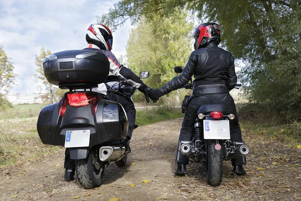 Dwóch Motocyklistów Trzymających Się Ręce Podczas Siedzenia Motocyklach — Zdjęcie stockowe