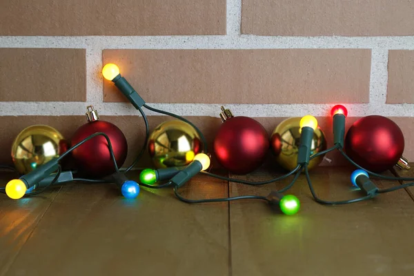 Несколько Рождественских Шаров Несколько Ярких Огней Деревянном Столе Кирпичная Стена — стоковое фото