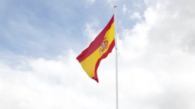 İspanya bayrağı mavi gökyüzüne karşı rüzgarda dalgalanıyor