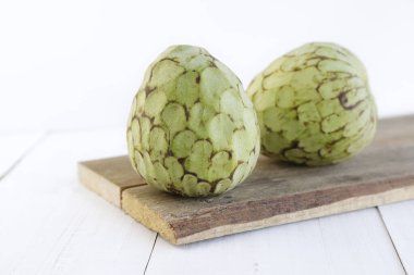 Beyaz arka planda kesim tahtasındaki iki muhallebi elması