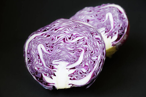 Several red cabbage against black background
