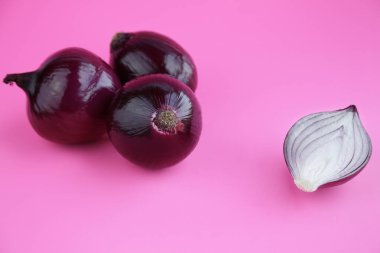 Pembe arka planda izole edilmiş kırmızı soğanlar