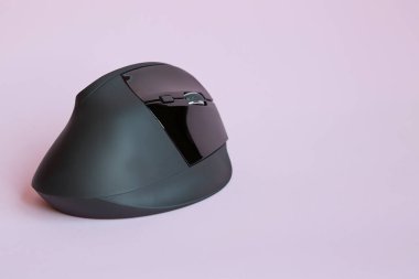 Pembe arkaplanda, kopyalama alanı olan siyah bir kablosuz fare görüntüsü