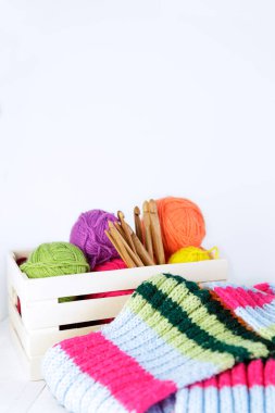 Doğal bambu kancalı ahşap kutu ve farklı renkte yün yumakları. Boşluğu kopyala