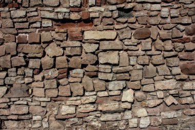 Sarı kireçtaşıyla kaplı eski bir taş duvar.