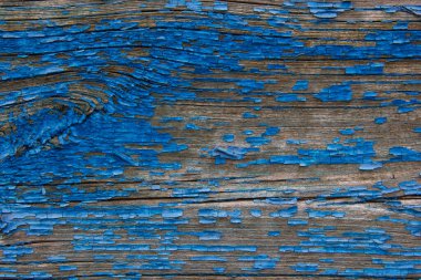 Kırık tahtalara mavi boya dökülüyor..