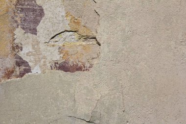 Kırık alçılı eski bir bej duvar..