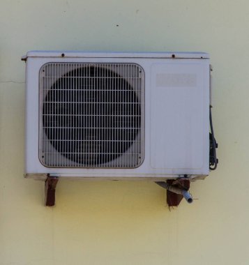 Duvara bağlı olan klima soluk sarı..