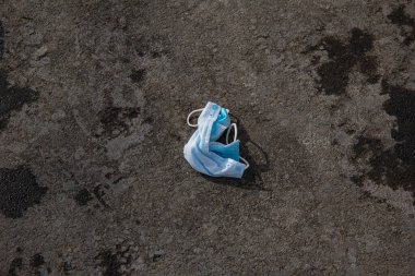Koronavirüs salgını sırasında yere atılan tıbbi maske..