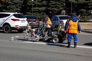 Orenburg, Orenburg bölgesi, Rusya - 04.20.2021: Pobeda Bulvarı 'ndaki yol onarımı. Yol işaretleri çiziliyor.