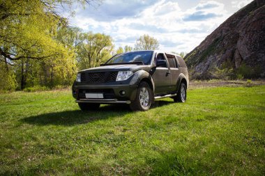 Orenburg bölgesi, Rusya - 05.08.2021: Dağların ve gökyüzünün arka planında Nissan SUV.