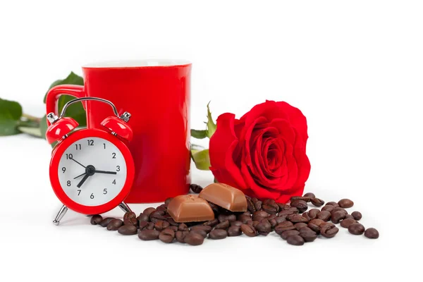 Bir bardak, bir saat ve beyaz zemin üzerine kırmızı gül