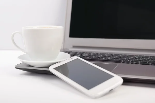 kahve ile bir dizüstü bilgisayar ve cep telefonu