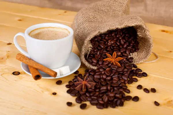 fincan kahve ve kahve çekirdekleri bir ahşap yüzeye