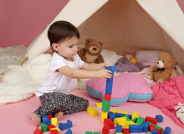 Barn spela: Låtsas spela med block och tältkåta tält — Stockfoto