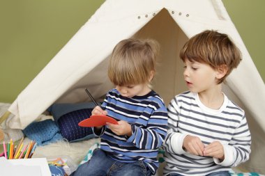 Çocuklar el sanatları etkinlik Teepee çadırda oynarken,