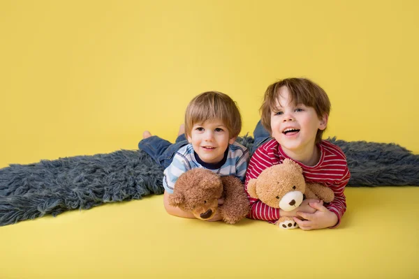 Niños felices, hermanos, abrazar juguetes de peluche —  Fotos de Stock