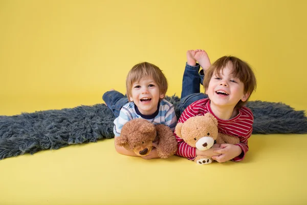 Niños felices, hermanos, abrazar juguetes de peluche —  Fotos de Stock